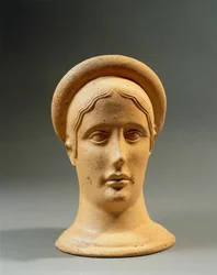 Primer plano de una cabeza femenina votiva de bronce con gorra, civilización itálica, siglo IV-III a.C.
