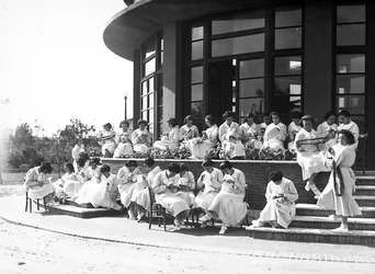 Villa Rosa Maltoni Mussolini: estudiantes femeninas durante una lección de costura, al aire libre (foto en b/n)