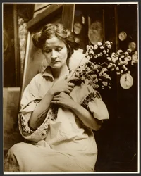 [Modelo femenino sosteniendo flores]