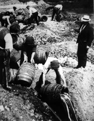 Un agente federal de EE.UU. supervisa la destrucción de barriles de cerveza durante la era de la Prohibición Americana (1920-33)