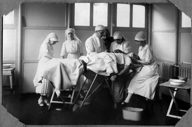 Primera Guerra Mundial 1914-1918: doctores y enfermeras de la Cruz Roja (¿Therese Pavillou?) tratando las heridas de un soldado durmiendo en cloroformo en el campamento de Couville en la Mancha, Baja Normandía, Francia. Fotografía anónima