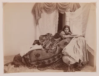 Foto de estudio de una dama reclinada leyendo un libro