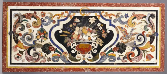 Una mesa de pietra dura florentina centrada por un cuenco de frutas y flores