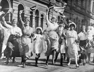 Grupo de mujeres y niños celebrando en una calle de Sídney la firma del Armisticio, 11 de noviembre de 1918