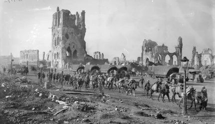 Una sección de ametralladoras australiana no identificada con caballos cargados pasando por las ruinas del Cloth Hall. Nótese varios camiones estacionados en el fondo, 19 de octubre de 1917