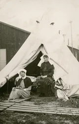 La enfermera Eleanor Wibmer Jeffries y la enfermera Nellie Constance Morrice (a la derecha) ante su tienda en el Hospital General Australiano n.º 3, con flores recogidas de la orilla del Somme, hacia junio de 1917