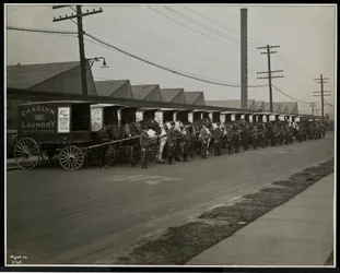 Carros de reparto tirados por caballos estacionados fuera de Carolyn Laundry en 111 East 128th Street, East Harlem, Nueva York, 1929
