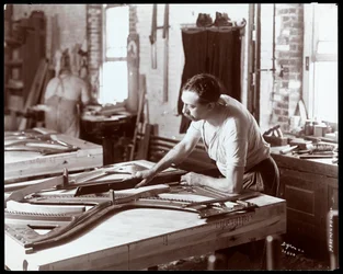 Hombre trabajando en la fábrica de pianos Hardman, Peck y Co., Nueva York