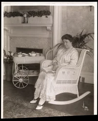 La Sra. Howard sentada con un libro en una mecedora en su casa en 200, 5th Avenue, Nueva York, 1915-6