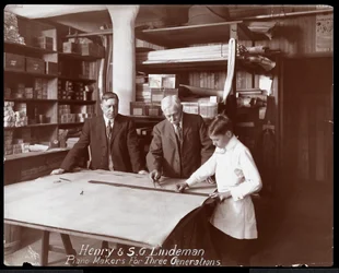 Retrato de Henry y S.G. Lindeman con su hijo o nieto sobre planos de una tienda para un piano