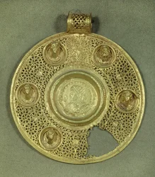 Medallón circular de oro: solidus de Constantino I el Grande (270-337 d.C.) acuñado en Sirmium en 321 d.C., en un marco de opus interrasile, adornado con 5 bustos en relieve. Siglo IV d.C. Sol 0,092 m París, Museo del Louvre