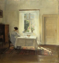 Una mujer sentada en una mesa junto a una ventana
