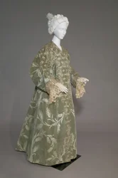 Abrigo de noche de Bertha Palmer, c.1902 (vista oblicua frontal). Satén de seda con terciopelo cortado en patrón de trigo, encaje de hilo metálico, borlas de seda metálica. Worth, París.