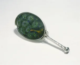 Espejo de mano diseñado por Ashbee con motivo de pavo real esmaltado por William Mark, realizado por la Guild of Handicraft, 1903