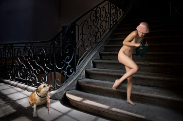 Mujer desnuda en una escalera oscura