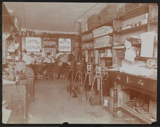 Laboratorio de películas Empire Film Co. (posiblemente en Broadway y la calle 55) con hombres trabajando y carretes de película y cámaras