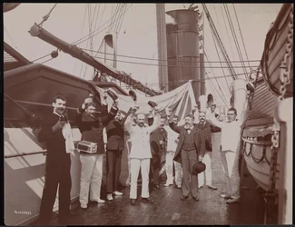 Oficiales y tripulación brindando con champán y cigarros en la cubierta del S.S. "Umbria", c.1897