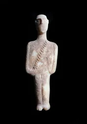 Ídolo masculino, figurilla esquemática. Escultura de mármol blanco con incrustaciones de ocre, 3200-2000 a.C.
