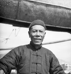 Retrato de uno de los tripulantes de un junco de sal de Cantón a bordo de su buque en Sham Shui Po, Hong Kong.