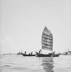 Un sampán a la vela y uno siendo craneado en el puerto de Penang