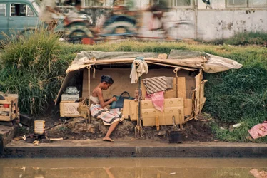 Choza de cartón, junto a un canal de aguas residuales, sirve de hogar. Yakarta, Indonesia.