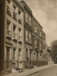 Tres pequeñas doncellas de la escuela en los escalones de la casa de Leigh Hunt, c1935