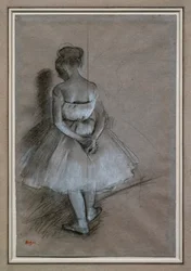Bailarina de pie, manos cruzadas detrás de la espalda