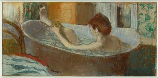 Mujer en la bañera, esponjándose la pierna