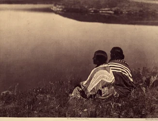 Una hora ociosa - Un momento de tranquilidad: Indios piegan sentados al borde de una masa de agua. Fotografía tomada del volumen 6 de la enciclopedia publicada por Edward S. Curtis (1868-1952) sobre los indios de Norteamérica, con prólogo de Theodore Roose