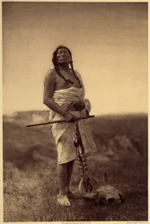 Médico varón. Probablemente sioux, con un calamar en la mano y un cráneo de búfalo en los pies. Fotografía tomada del volumen 3 de la enciclopedia de Edward S. Curtis (1868-1952) sobre los indios de Norteamérica, con prólogo de Theodore Roosevelt. Entre 19