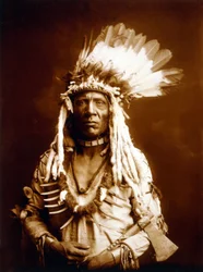 Cola de Comadreja, Piegan, con un Tomahawk, c. 1900, foto Edward S. Curtis