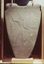 La paleta de Narmer: paleta ceremonial que representa al rey Narmer, con la corona blanca del Alto Egipto, golpeando a un prisionero, hallada en Hieracómpolis, periodo dinástico temprano, hacia 3000 a. C. (esquisto) (detalle)