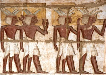 Antigüedad egipcia: primer patio, detalle de relieves pintados representando un grupo de nubios trayendo ofrendas al faraón. Templo funerario de Ramsés III (1187-1156 a.C.). Luxor, Medinet Habou, Egipto