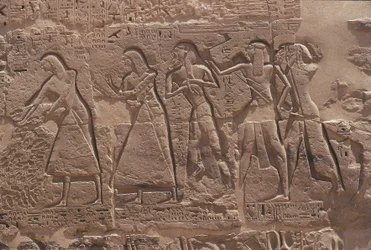 Relieve de escriba y cautivo en el templo fortificado de Ramsés III en Medinet Habu
