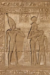 Antigüedad egipcia: mammisi romano conmemorando el nacimiento de Ihy, hijo de Hathor - Detalle de relieves y jeroglíficos: la diosa Isis - Hathor amamantando a su hijo Ihi (Ihy) y detrás de ella otra imagen de Ihi con un dedo en la boca indicando que es un