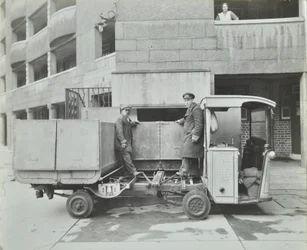 Ossulston Estate: basureros vaciando contenedor al fondo del conducto de basura