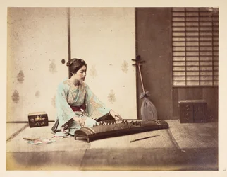 Chicas cantantes [Japón], Retrato de estudio de una joven japonesa sentada sobre un tatami tocando un instrumento de cuerda,  Fotógrafo: Desconocido  Colección Lucas: Registro fotográfico de la gira mundial de Charles James y Morton P, Lucas