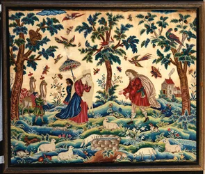 Una imagen de bordado fino en lanas y sedas, probablemente representando el encuentro de Jacob y Raquel en el Pozo