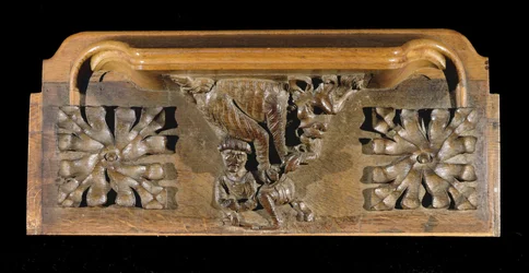 Una misericordia que representa a una pequeña figura con gorra atacada por un monstruo, Capilla del New College, Oxford, finales del siglo XIV (madera)