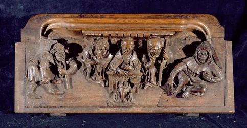 Una misericordia que representa a un académico sentado en un escritorio panelado dando una amonestación a un penitente arrodillado, Capilla del New College, Oxford, finales del siglo XIV (madera)