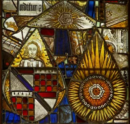 Un panel en la ventana este que representa un ángel con un escudo de armas y 2 rosas dentro de resplandores solares