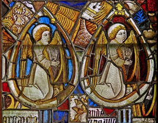Un panel en la ventana este que representa a dos ángeles músicos con arpas entre fragmentos
