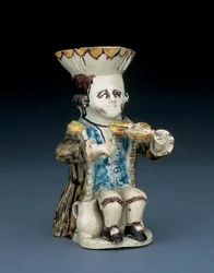 Jarra Toby del violinista, su sombrero con borde festoneado marrón y amarillo, su cabello castaño inciso y recogido en coleta con una roseta blanca, con una levita bañada en marrón, ca. 1770