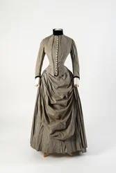Vestido de algodón gris con delantero de delantal drapeado y ribetes de terciopelo negro en cuello y puños, finales de la década de 1880