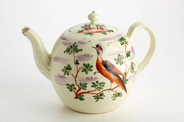 Tetera de Staffordshire decorada con pájaro exótico y edificio entre árboles, c.1765-75