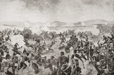 La batalla de Ulundi en 1879, que muestra la acometida final de los zulúes y la plaza británica a lo lejos, de "South Africa and the Transvaal War: Vol. 1" de Louis Creswicke, publicado en 1900 (litografía).