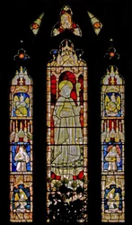La ventana este que representa ángeles músicos rodeando la figura central de un obispo santo