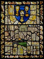 La ventana este que representa un escudo con emblemas del Sacramento; fragmentos de dosel con figuras