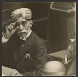 [Hombre sentado con turbante y gafas oscuras]