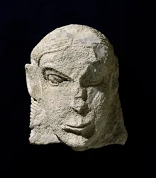 Civilización etrusca: cabeza de mujer de piedra caliza. 650 a.C. aprox. Del túmulo de la Pietrera di Vetulonia. Florencia, Museo Arqueológico